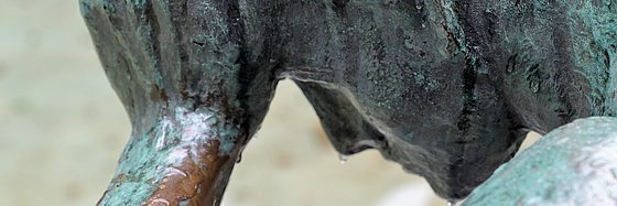 Bronze Skulptur eines niedergeschlagenen Mannes, der sein Gesicht in seinen Händen vergräbt.