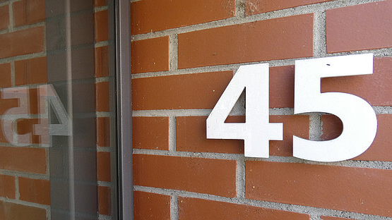 Hausnummer 45 am Engang unseres Gebäudes spiegelt sich in Glasscheibe