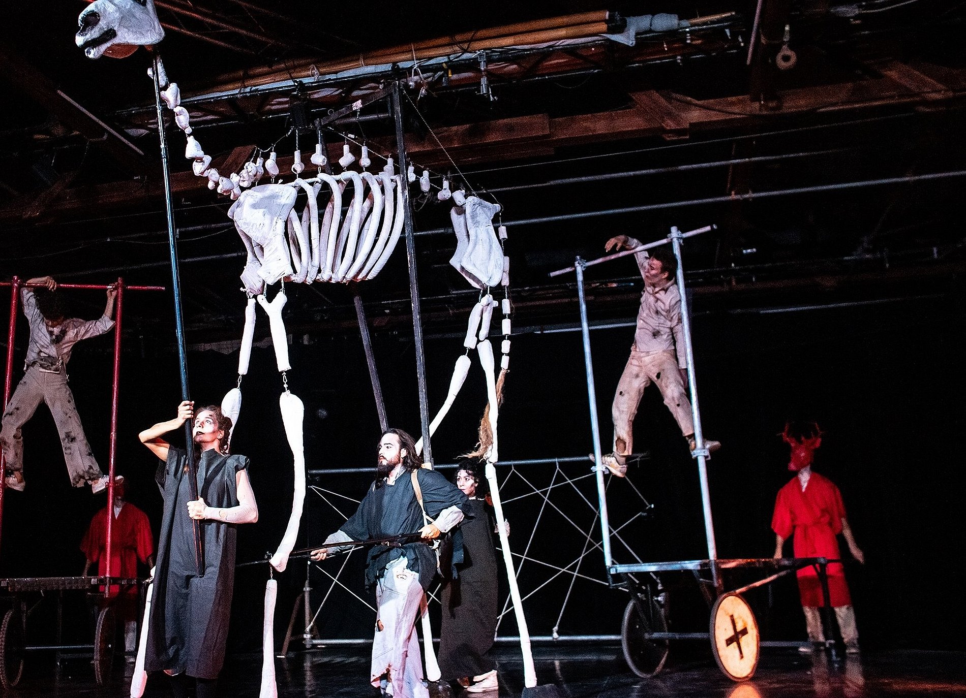 Bunt gekleidete Schauspieler mit einem übergroßen Tierskellett