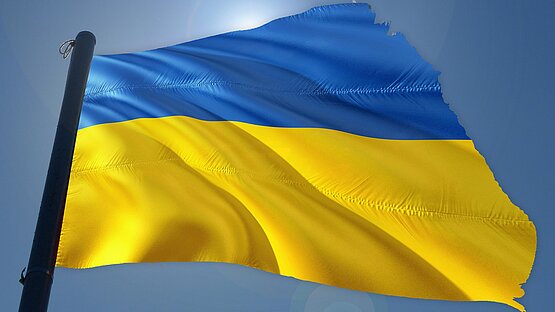 Blau gelbe Flagge der Ukraine leicht zerfleddert an Fahnenmast
